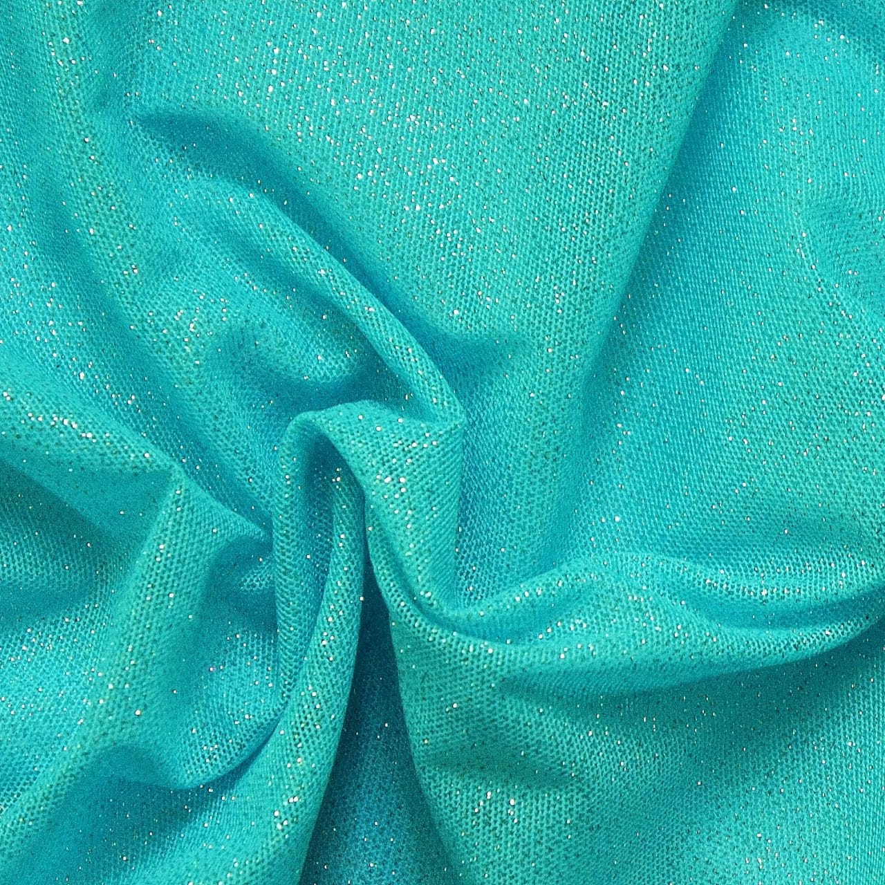 Turquoise Glitter Mesh fabric features all over turquoise glitter on 2-way stretch turquoise polyester mesh making it ideal for both semi-fitted and draped garments.