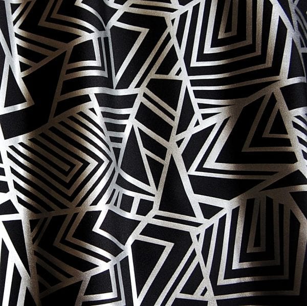 Geometry Matte Silver Geometric fabric features bold geometric designs in a sleek matte silver foil on black stretch base fabric for a stunning contrast effect.  - SOLID STONE FABRICS, INC.