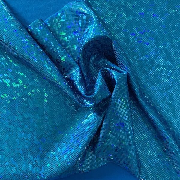 Turquoise broken glass fabric featuring turquoise stretch base fabric topped with turquoise shattered glass holographic foil, for brilliant shine and sparkle.