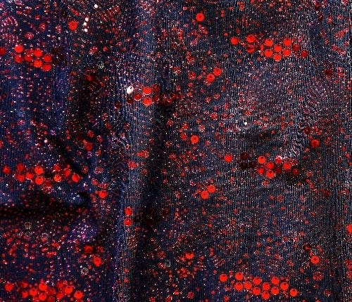 Red Sequin Glitter Mesh Fabric features glitter and sequins on sheer stretch mesh base fabric for a glamorous look with lots of sparkle!  2-way stretch and excellent draping characteristics makes this an ideal fabric choice for both semi fitted and loose fitting garments.