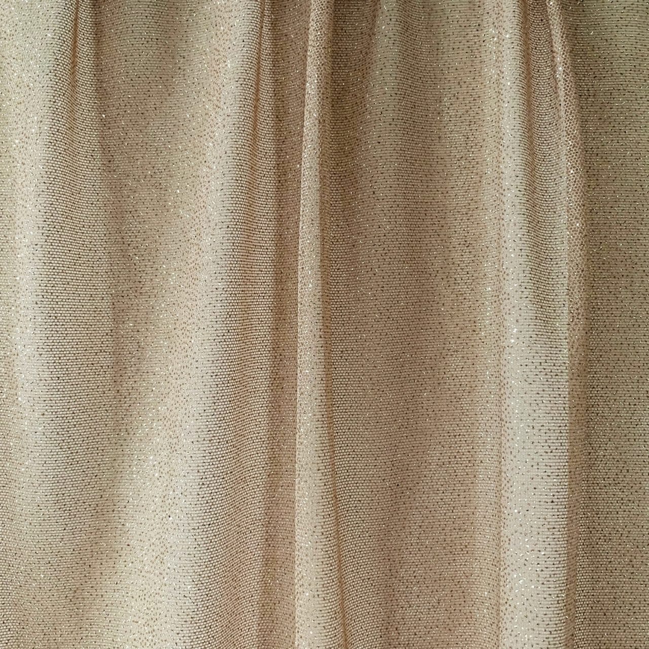 Nude Gold Glitter Mesh fabric features all over gold glitter on 2-way stretch nude polyester mesh making it ideal for both semi-fitted and draped garments.